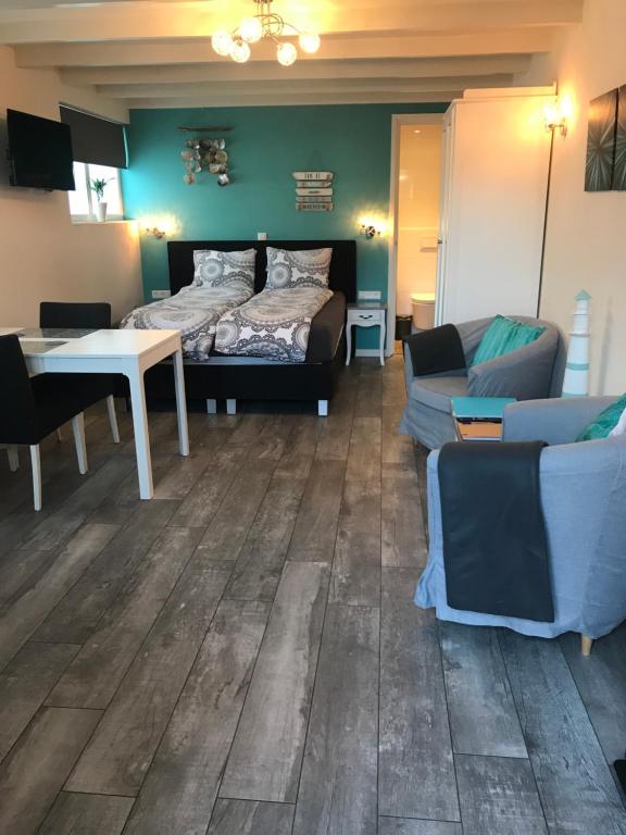 um quarto com uma cama, um sofá e uma mesa em Mikasabeach em Zandvoort