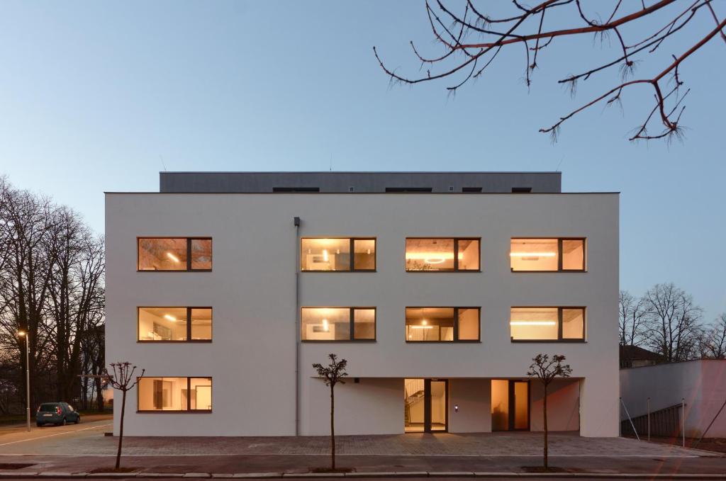 a white building with lights in the windows at Střešní apartmán s terasou in Hradec Králové