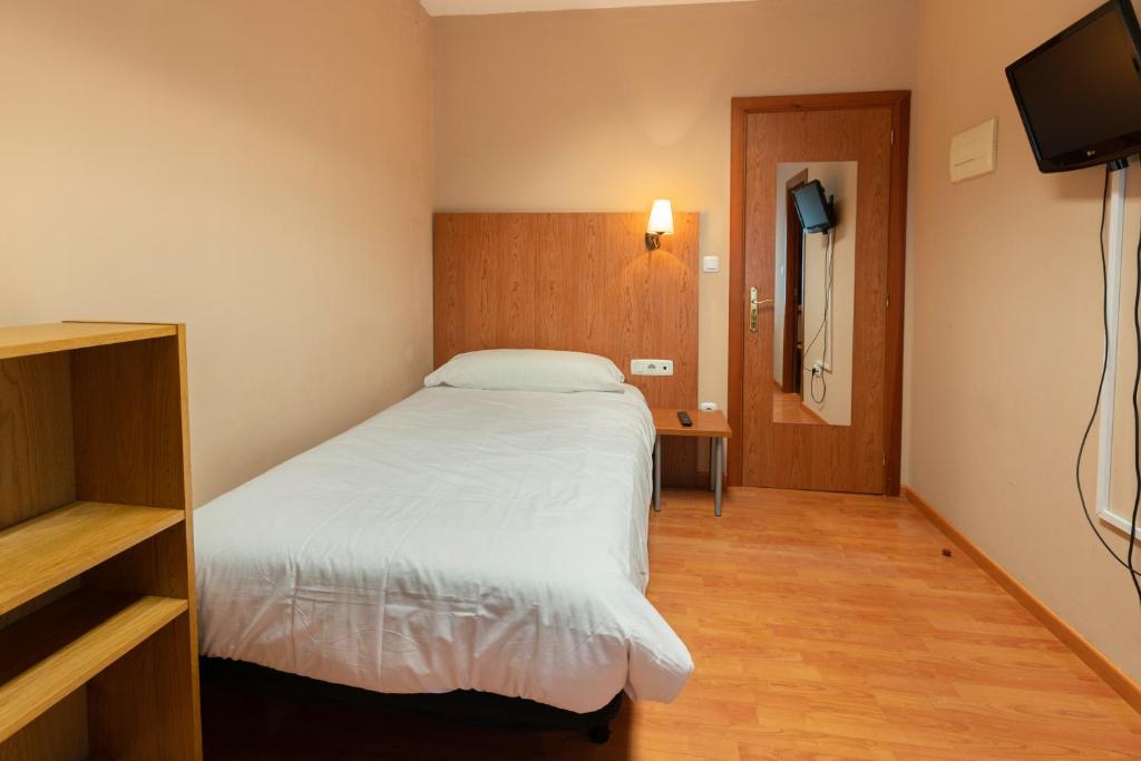 a bedroom with a white bed and a television at RESIDENZA in Zamora