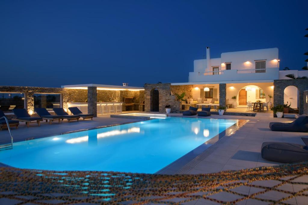 a swimming pool in front of a villa at night at Zoe & Zen Collection in Kampos Paros