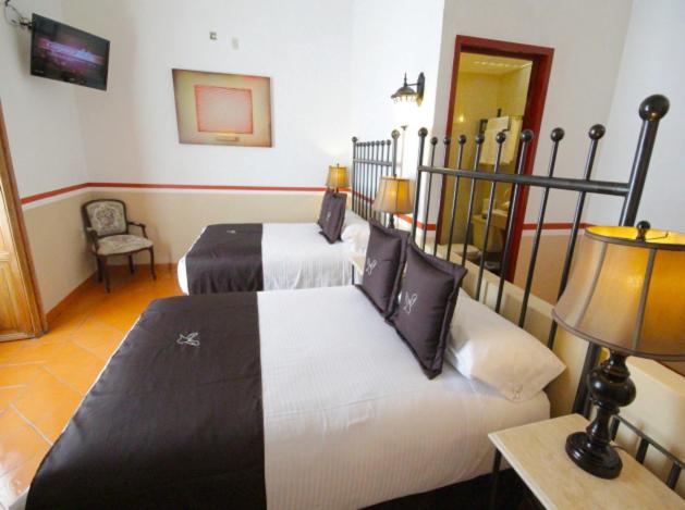 Postel nebo postele na pokoji v ubytování Hotel de la Paz