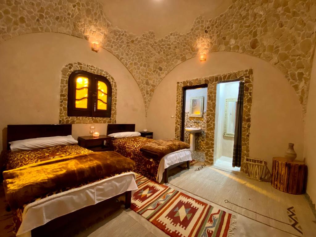 a bedroom with two beds and a mirror on the wall at Grand Siwa in Siwa