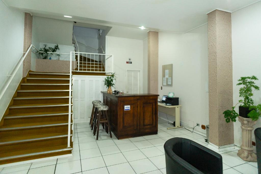 uma sala de estar com escadas, uma mesa e uma secretária em Hotel Igrejinha em Igrejinha