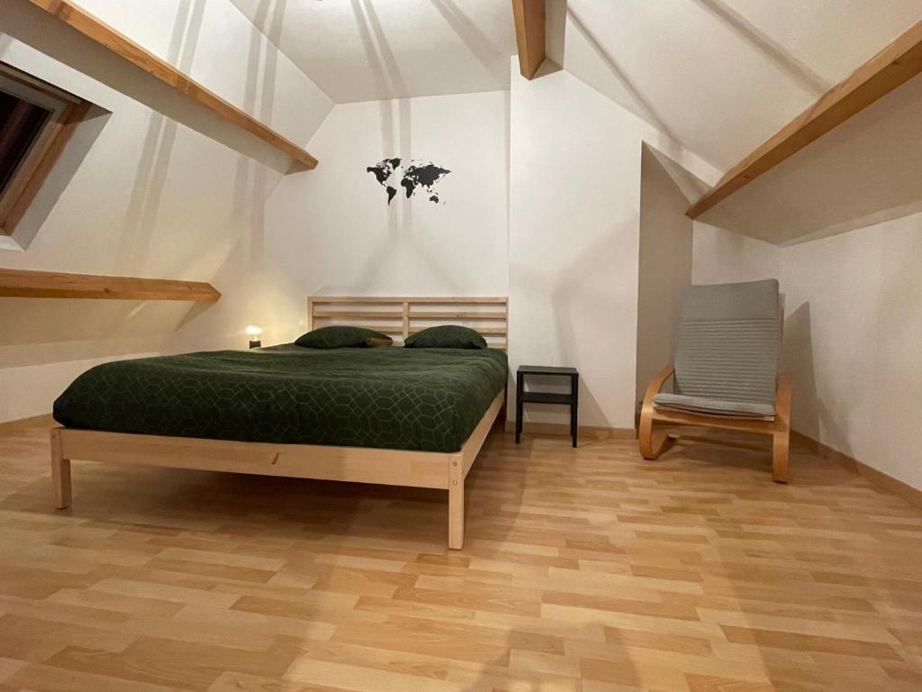 a bedroom with a bed and a chair at Gîte à la campagne mais proche de tout in Moringhem