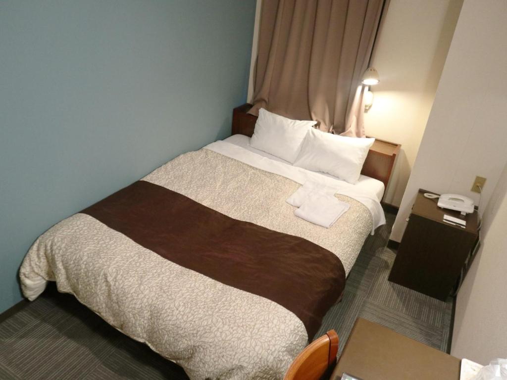 濱松的住宿－Hamamatsu Station Hotel - Vacation STAY 65830，配有一张大床和一部电话的酒店客房