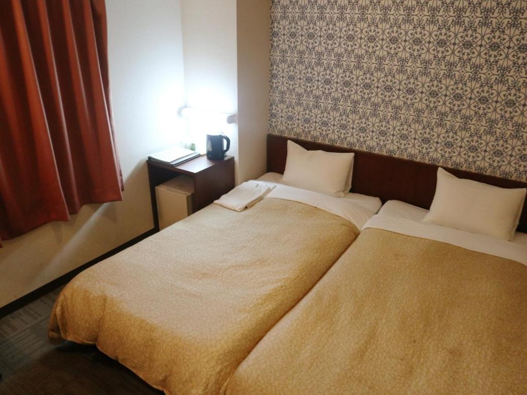 a hotel room with two beds in a bedroom at Hamamatsu Station Hotel - Vacation STAY 65834 in Hamamatsu