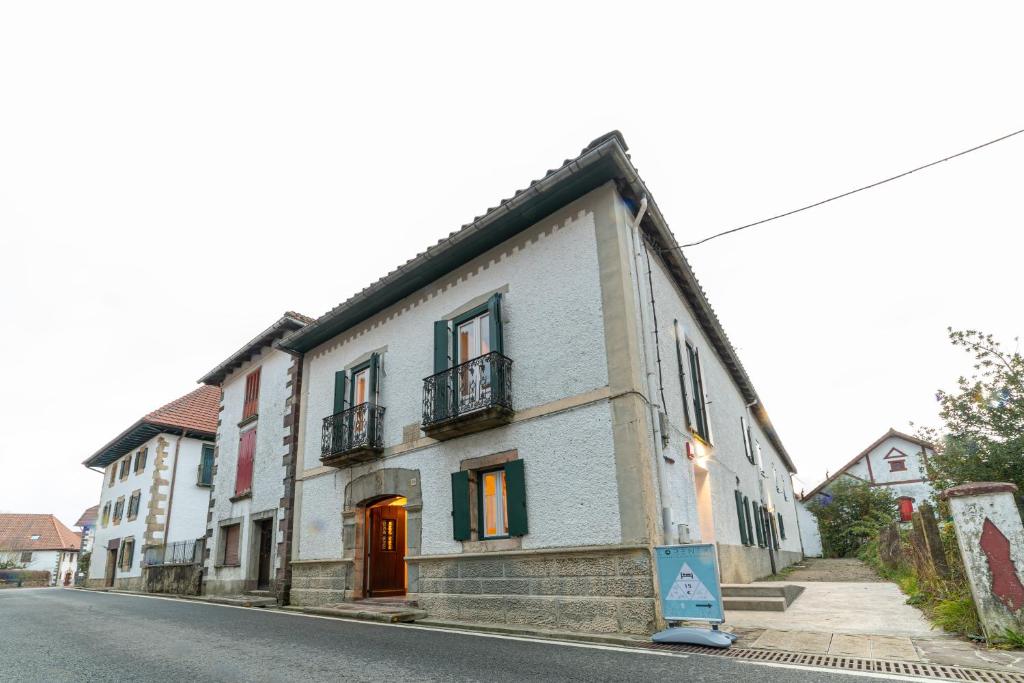 un edificio blanco al lado de una calle en LORENTX ATERPEA, en Burguete