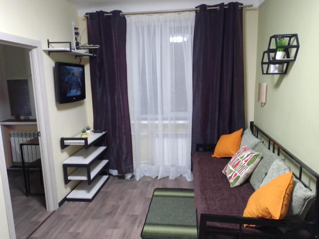 uma sala de estar com um sofá e uma janela em Apartments KVADRO Dnepr, ул Холодноярская, 19, Метеор Апполо Рабочая Титова em Dnipro