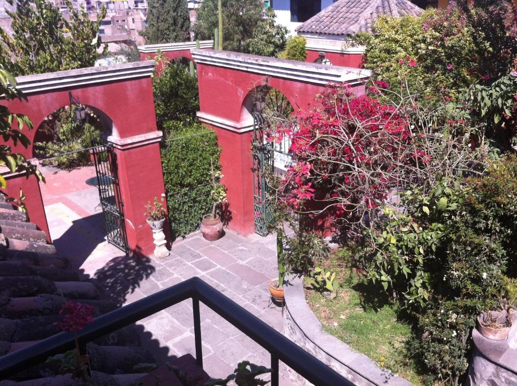 un edificio rojo con una puerta y algunas plantas en Hostal Tres Máscaras, en Ayacucho