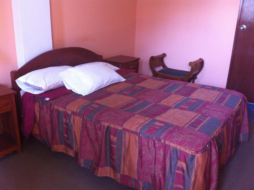 Postel nebo postele na pokoji v ubytování Hostal Tres Máscaras