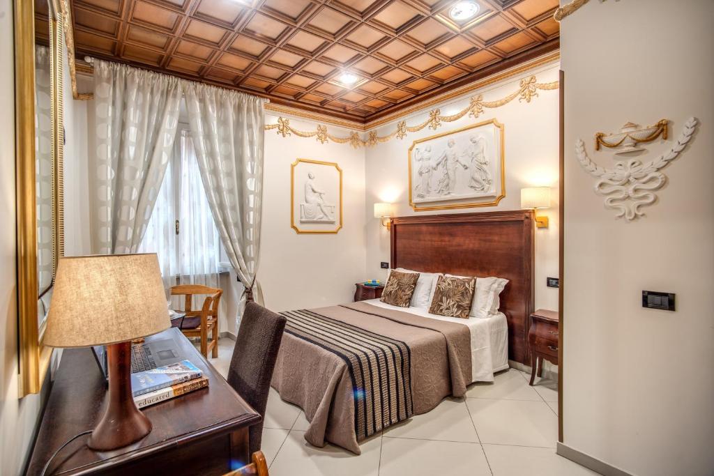 a bedroom with a bed and a desk with a lamp at Artemis in Rome