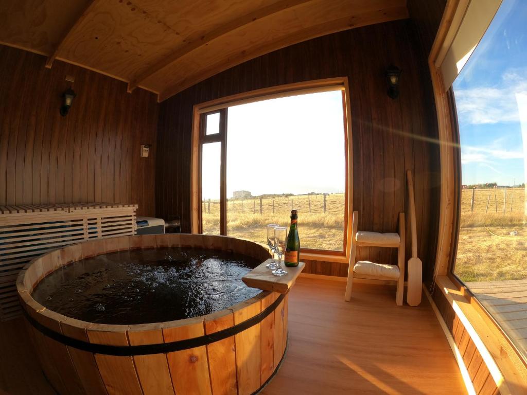 a large wooden tub in a room with a window at Cabañas Las Lengas in Puerto Natales