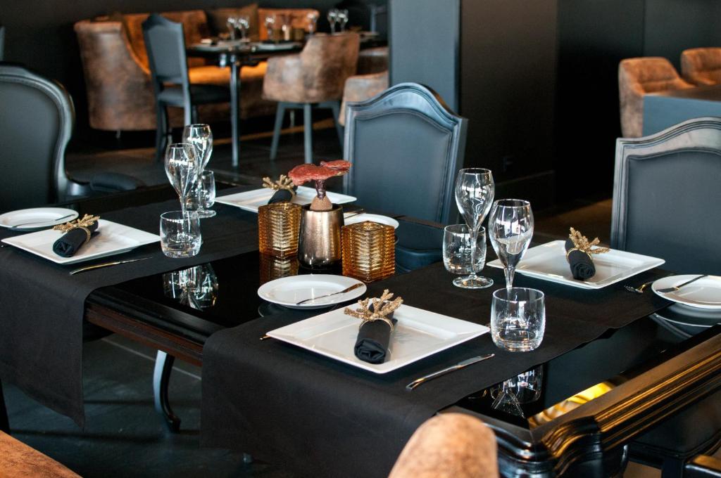 a table in a restaurant with plates and wine glasses at Evidencia Belverde Hotel in Amora