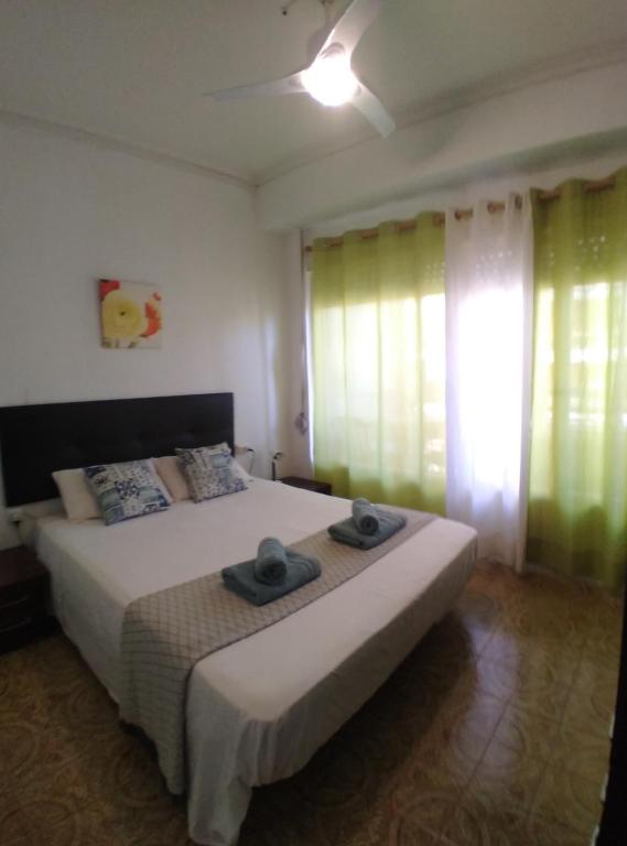 Un dormitorio con una cama con dos sombreros encima. en LOVE ALICANTE, en Alicante