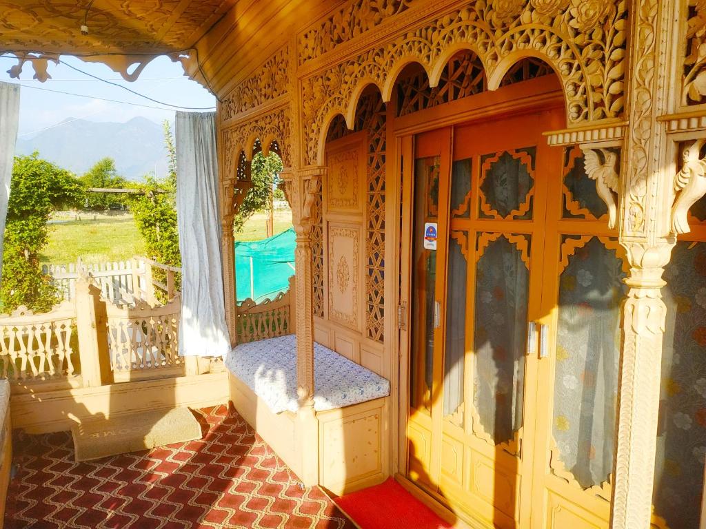 Cette chambre dispose d'une terrasse couverte avec un lit. dans l'établissement Houseboat New Jeddah, à Srinagar