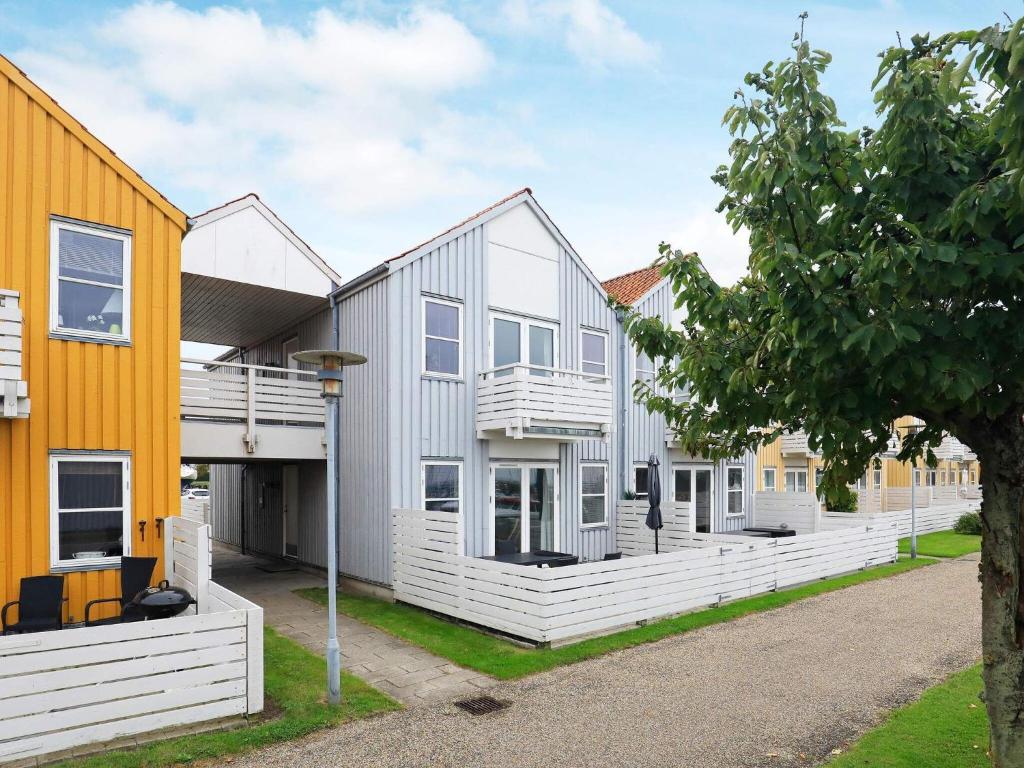 a group of houses with a yellow building at 6 person holiday home in Rudk bing in Rudkøbing