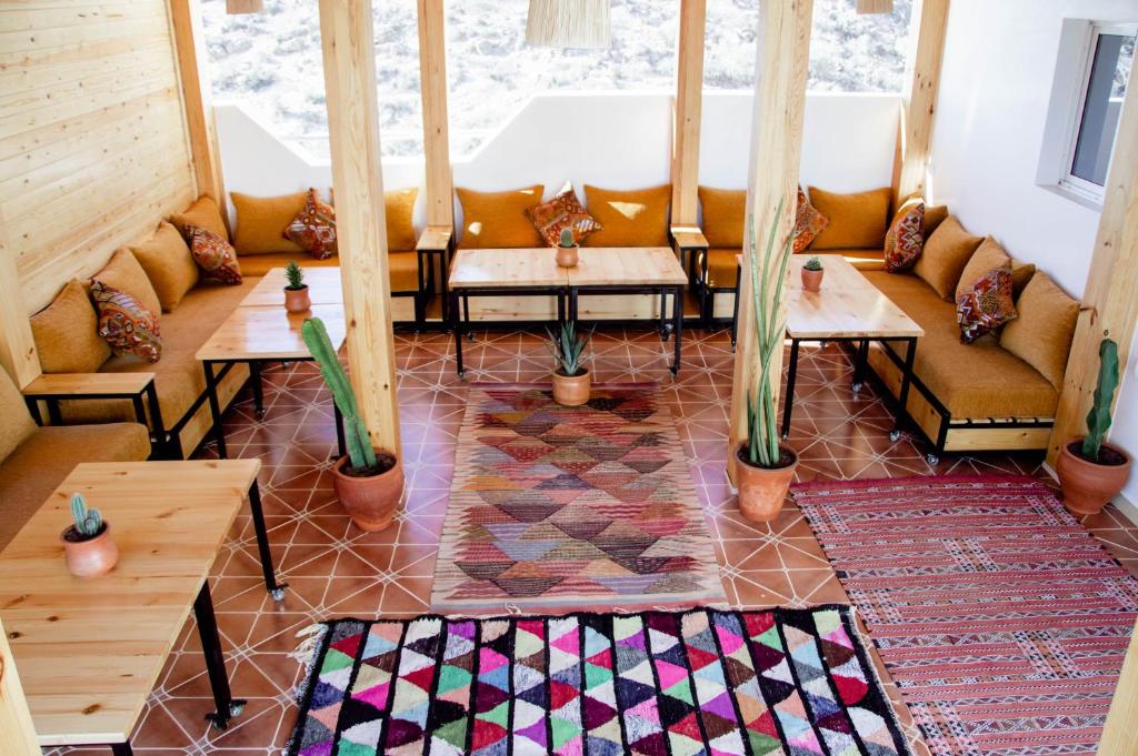 una habitación con sofás, mesas y una ventana en Mouja Surf Camp en Taghazout