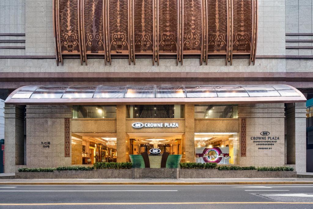 Crowne Plaza Shanghai Nanjing Road, an IHG Hotel في شانغهاي: محل امام مبنى على شارع