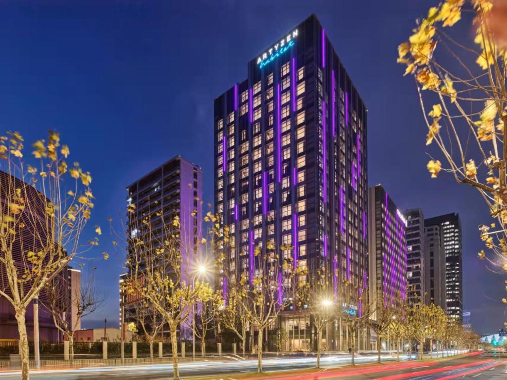 a tall building with purple lights on it at Artyzen Habitat Qiantan Shanghai in Shanghai