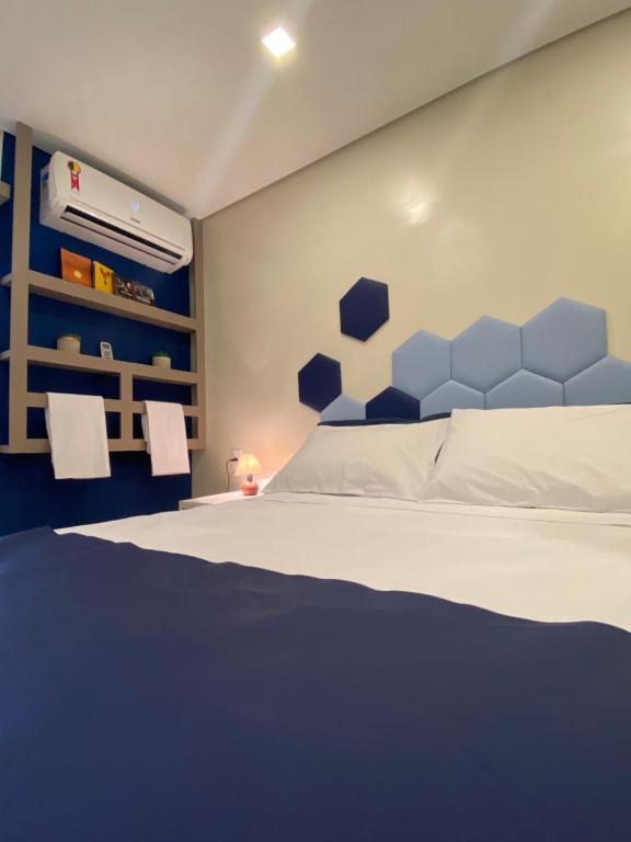 um quarto com uma cama com uma cabeceira azul em URBAN BOX HOUSE em São Paulo