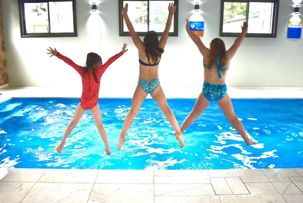 a group of girls jumping in a swimming pool at Yarram Holiday Park in Yarram