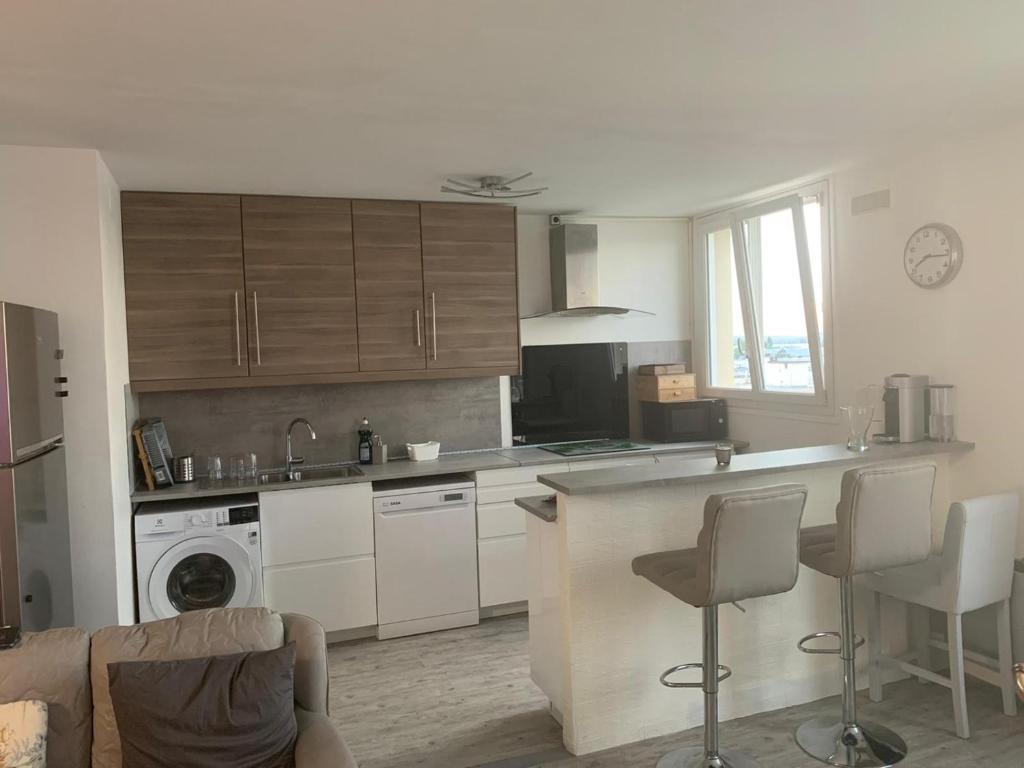 a kitchen with white cabinets and a counter top at Grand appartement proche de Paris in Chilly-Mazarin