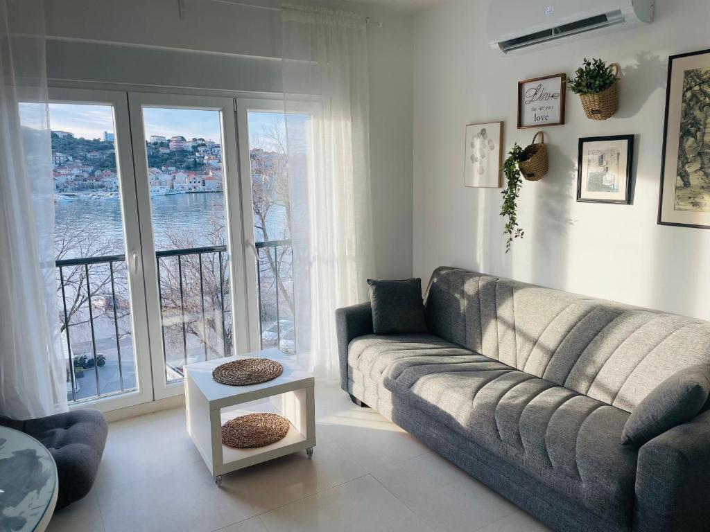 uma sala de estar com um sofá e uma grande janela em Trogir Penthouse IVY em Trogir