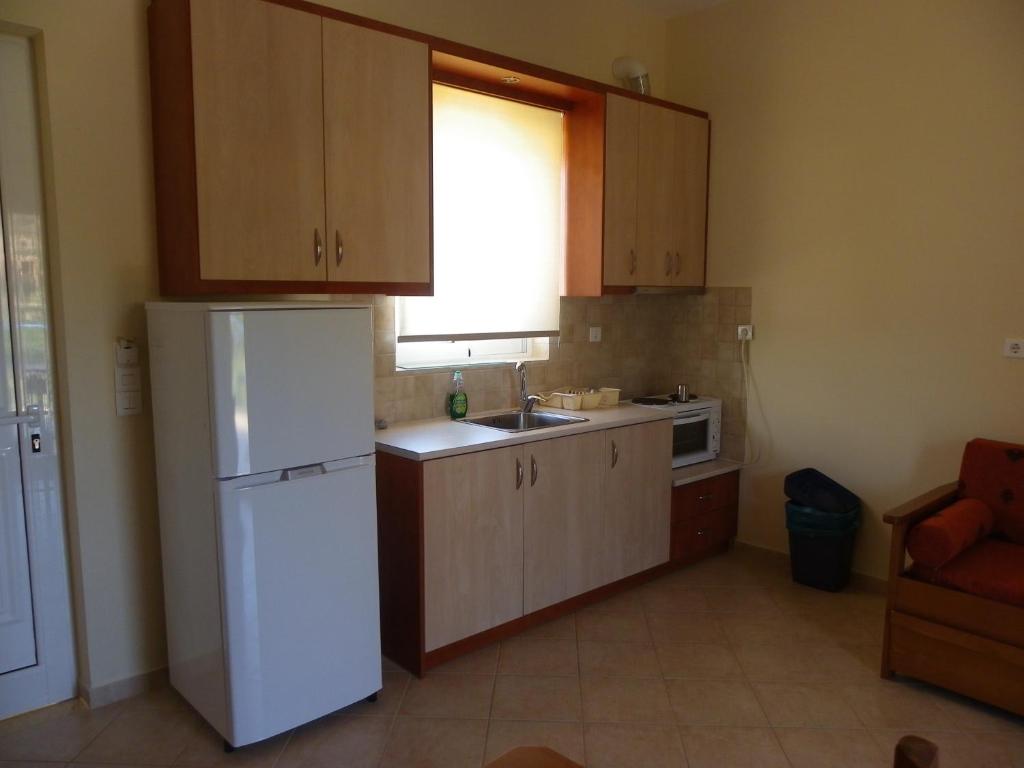 eine Küche mit einem weißen Kühlschrank und einer Spüle in der Unterkunft Hotel Sea in Erateini