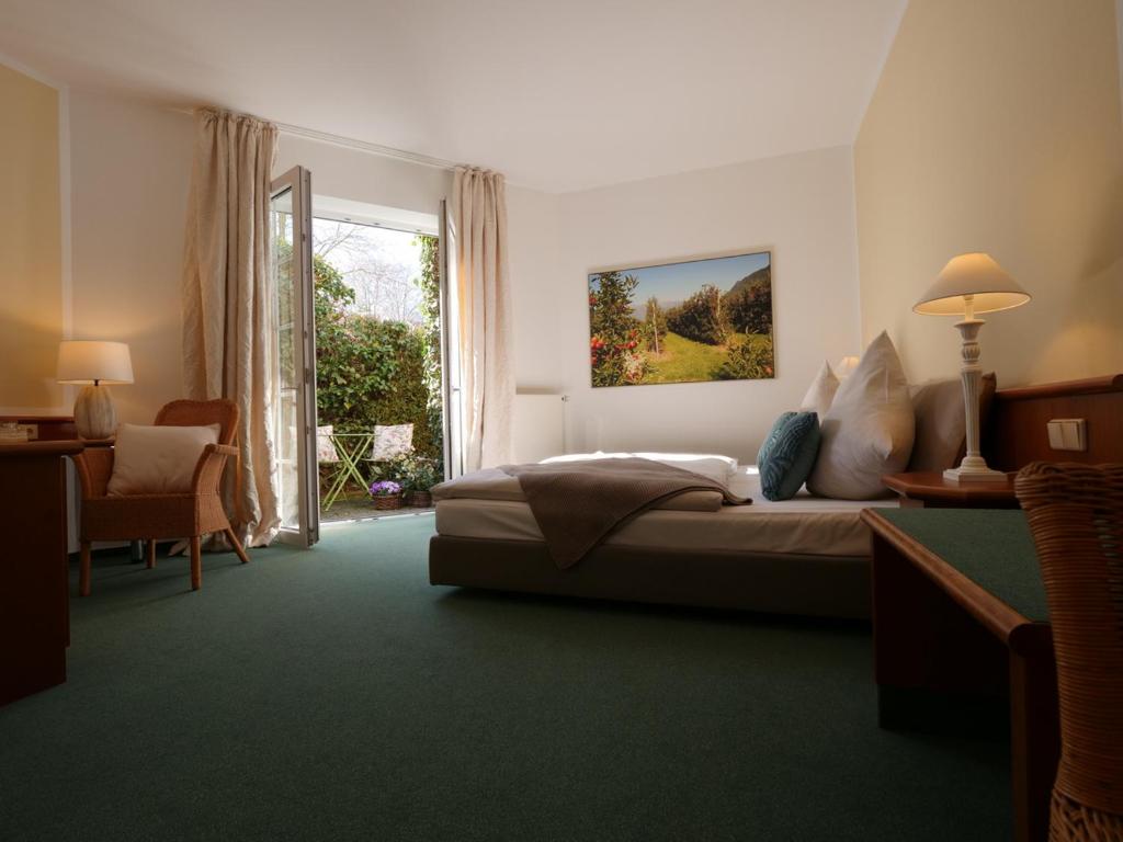 a bedroom with a bed and a large window at Privathotel Bremer in Bergisch Gladbach