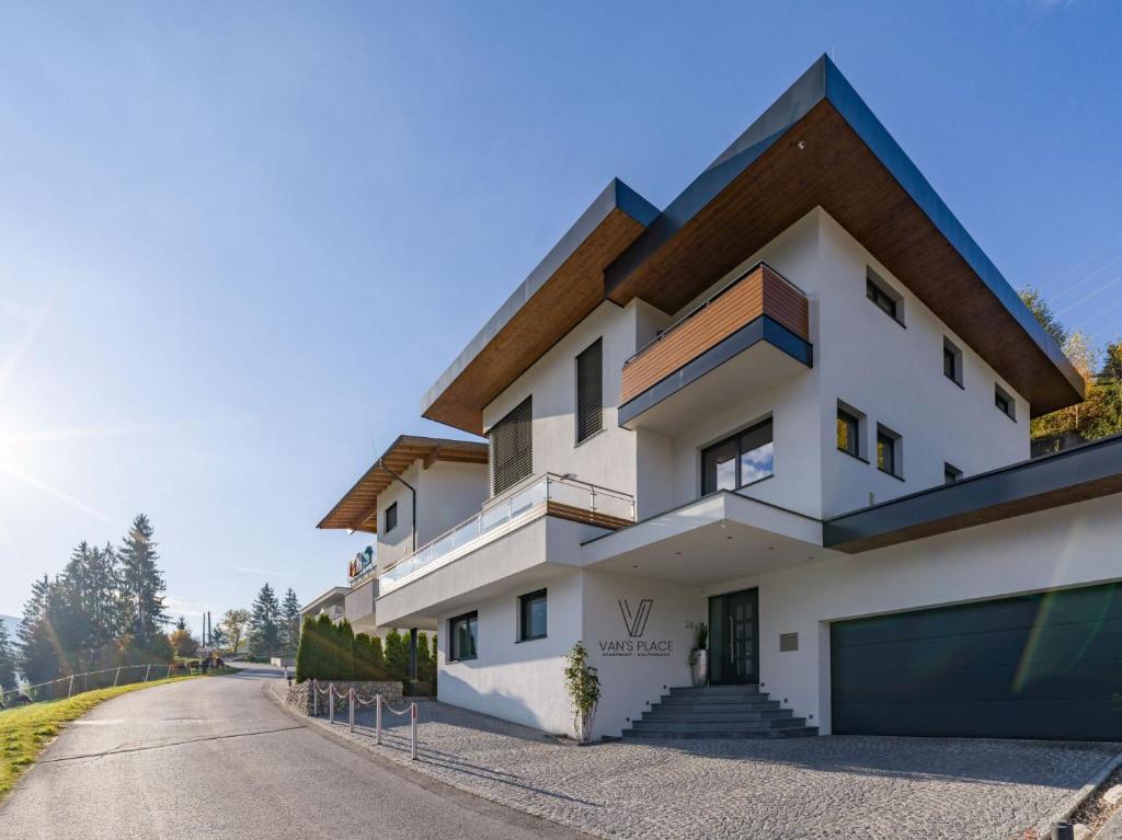 ein weißes Haus mit Garage auf einer Straße in der Unterkunft Van's Place, Luxury Apartment in Kaltenbach