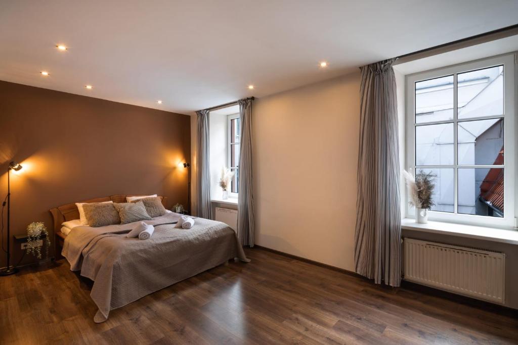 a bedroom with a bed and a large window at Old Riga Aldaru Street Historic One Bedroom Apartment in Riga