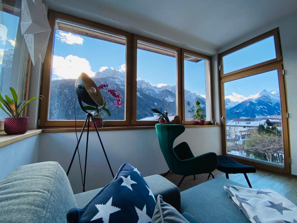 a living room with a view of mountains at Das Stubai - exklusiv, einzigartig & nachhaltig in Fulpmes
