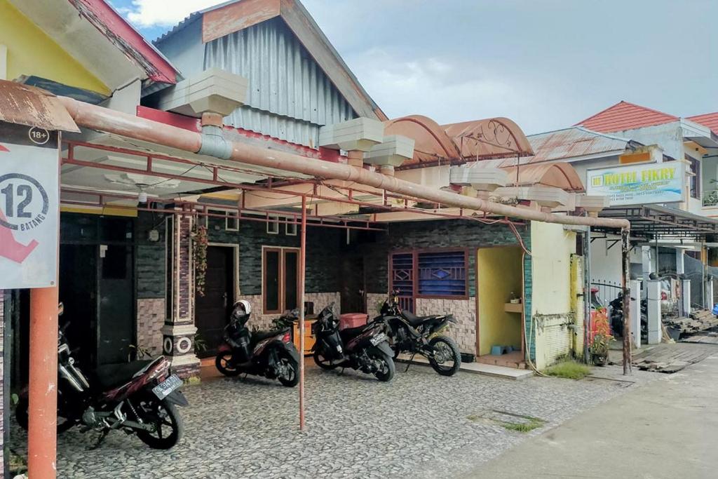 een groep motorfietsen geparkeerd voor een gebouw bij Hotel Fikry Toli Toli in Tolitoli