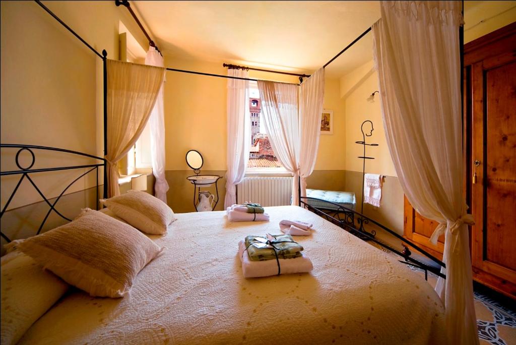 sypialnia z dużym łóżkiem w pokoju z oknem w obiekcie Bed and Breakfast Evelina w Lukce