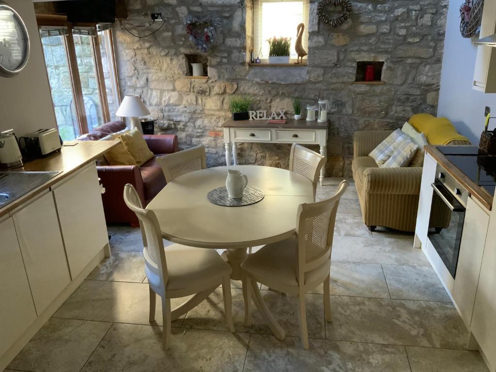 a kitchen and living room with a table and chairs at Chater Cottage Rothbury in Rothbury