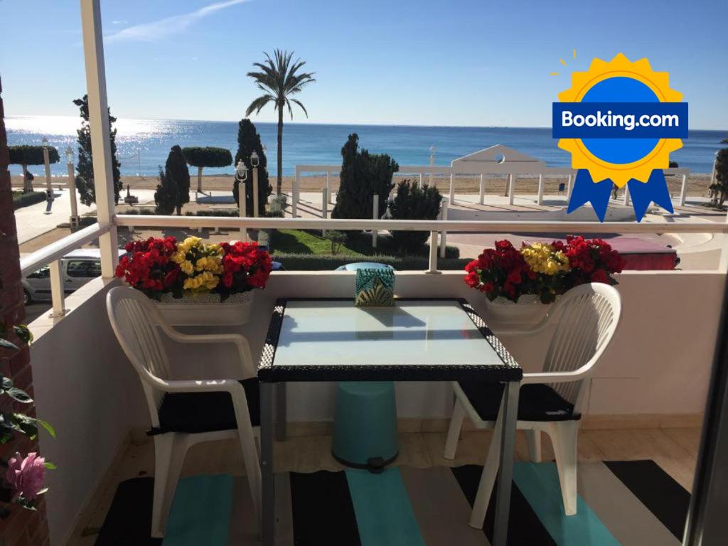 una mesa y sillas con vistas a la playa en MAGNÍFICO APARTAMENTO JUNTO A LA PLAYA!, en Altea