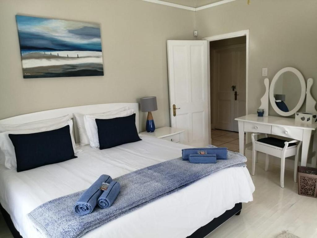a bedroom with a bed with blue towels on it at Summer House in Hermanus