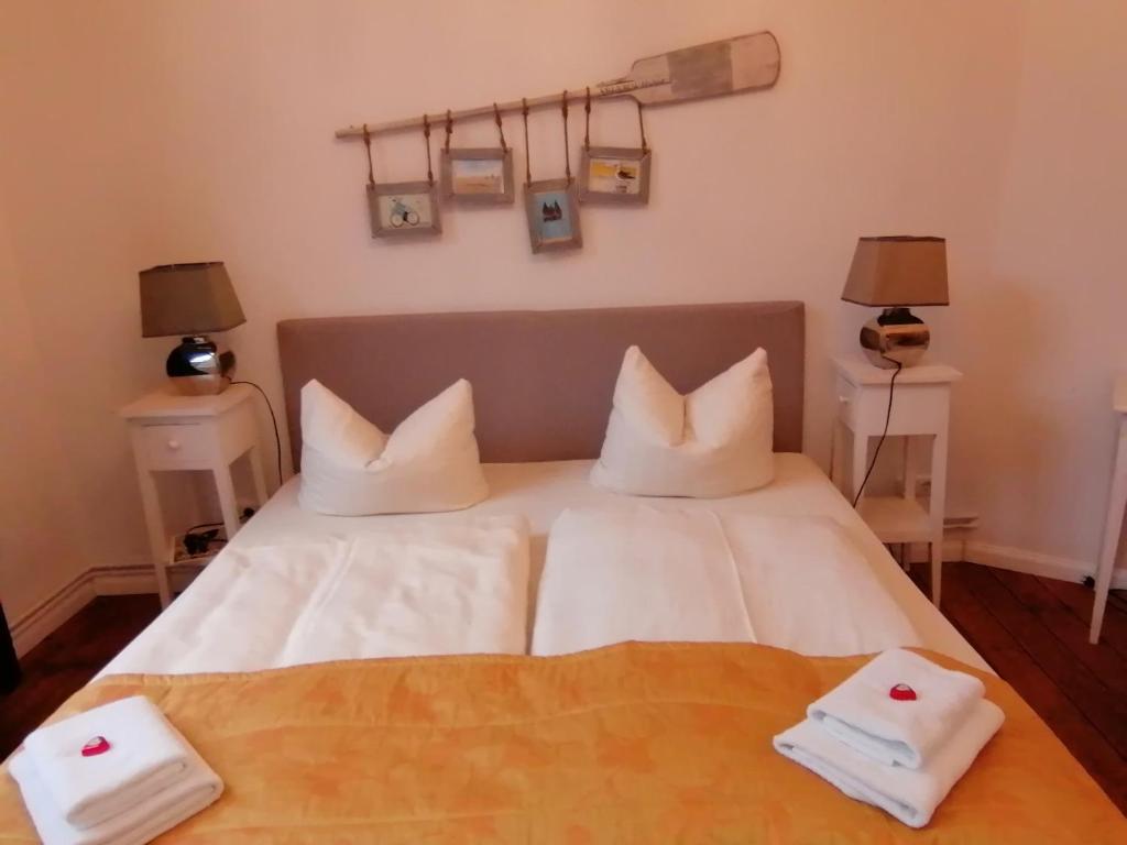 Un dormitorio con una cama con almohadas blancas. en Babette Apartments, en Lübeck