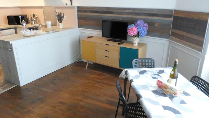 een kamer met een tafel en een keuken met een aanrecht bij Le gite du Mont in Val Couesnon