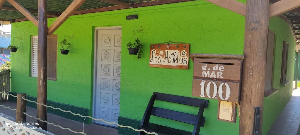 una casa verde con un cartel en el costado. en Los Abuelos, en La Coronilla