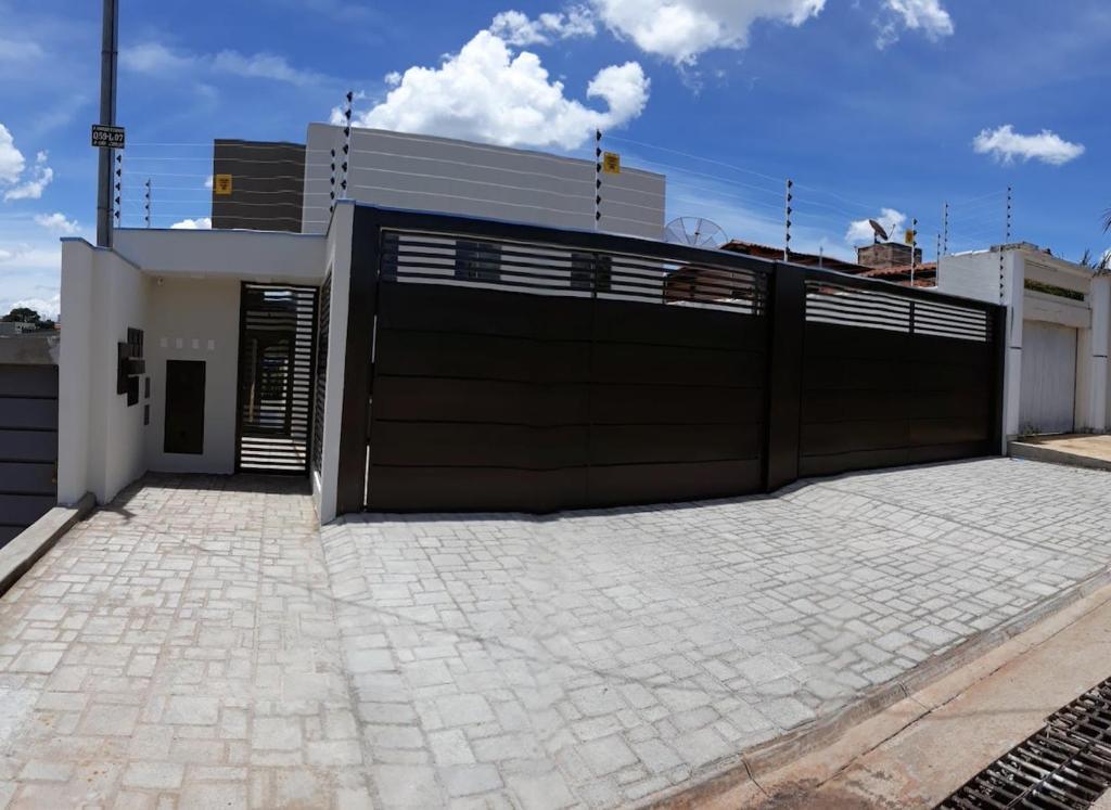 un garaje con una gran puerta negra delante de una casa en Apto inteiro Seguro e Confortável com piscina, en Anápolis