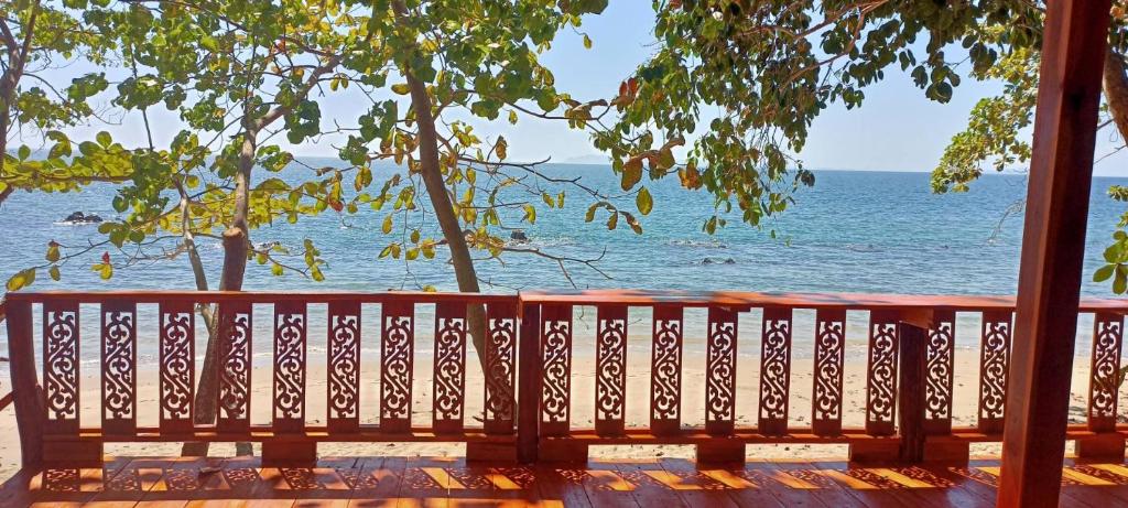 a wooden bench looking out at the ocean at Kohjum Seafront Resort in Ko Jum