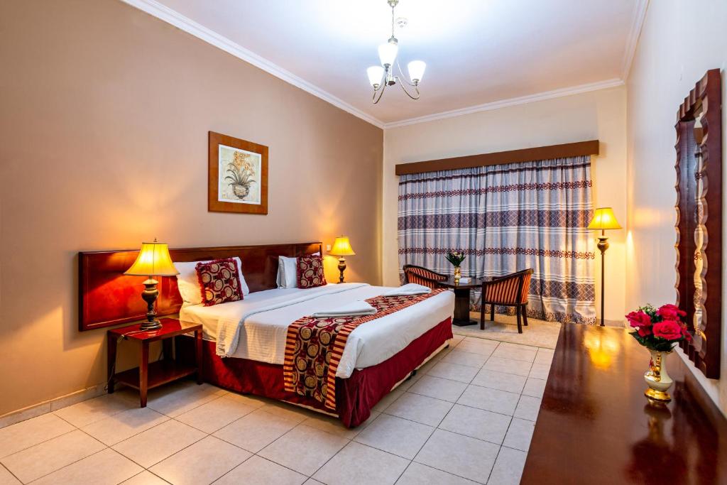 um quarto com uma cama e uma mesa num quarto em Icon Hotel Apartments no Dubai