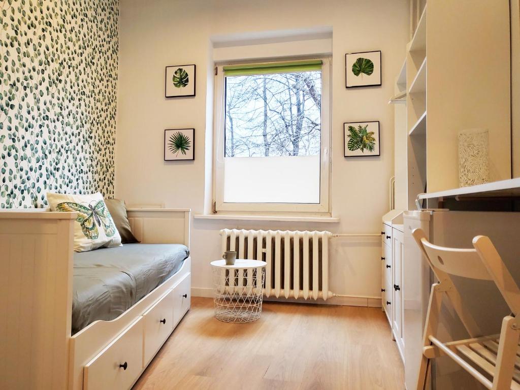ein kleines Schlafzimmer mit einem Bett und einem Fenster in der Unterkunft Centrum Apartament Bolka in Świdnica