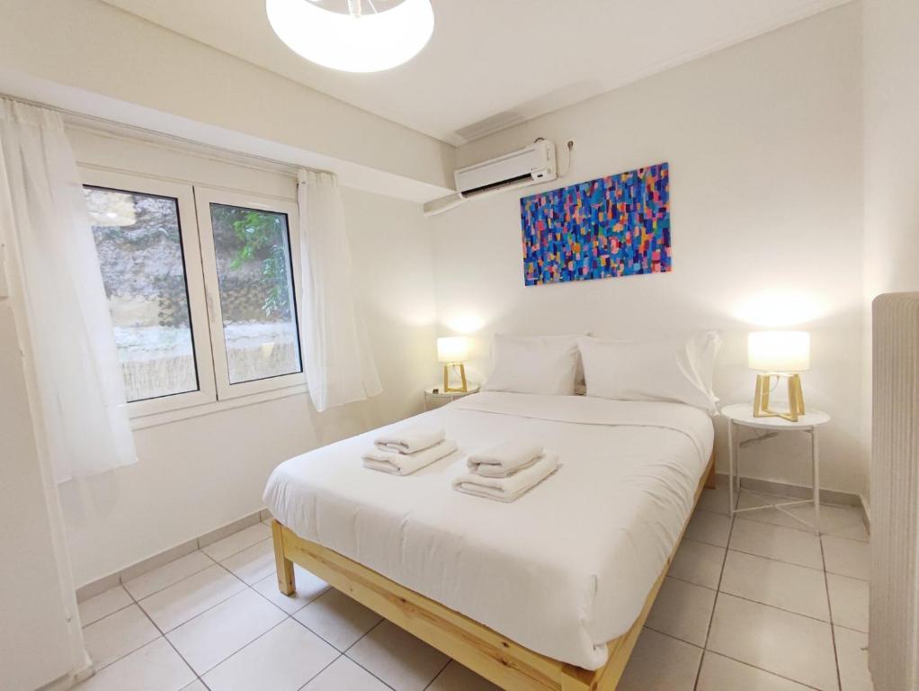 a bedroom with a white bed with two towels on it at Avli apartment in Athens