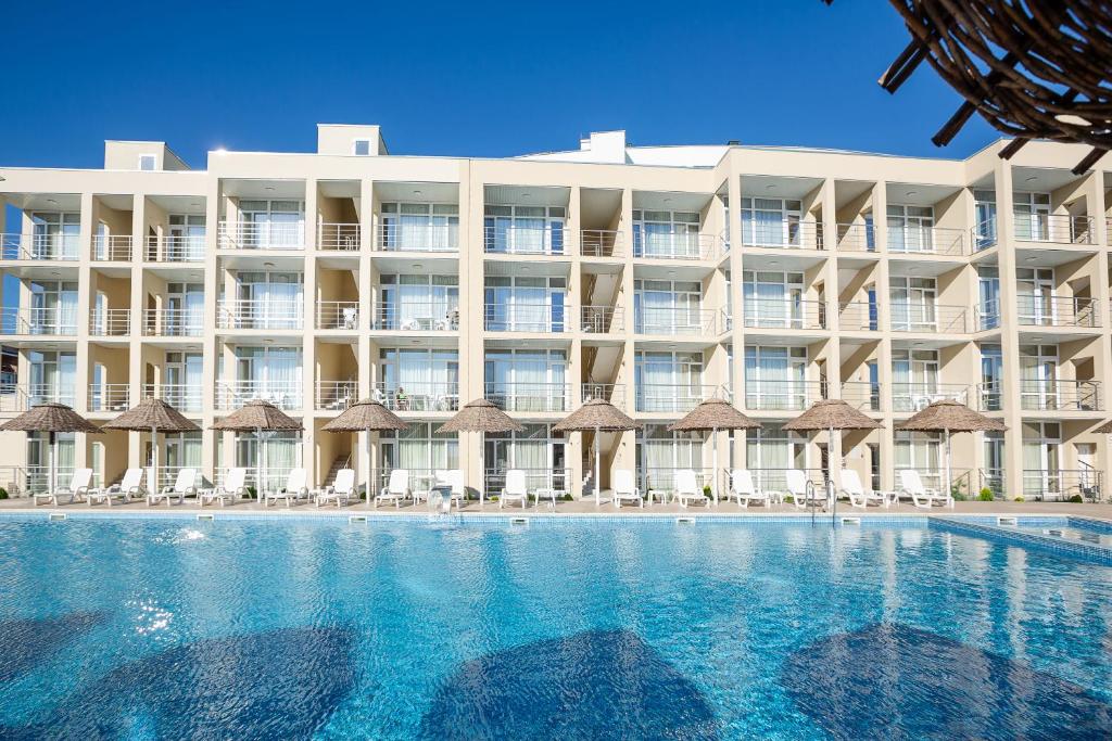 un hotel con una grande piscina con sedie e ombrelloni di GRAND Hotel a Zatoka