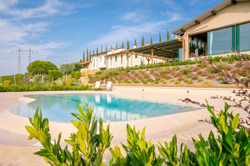 una piscina di fronte a una casa di Le Bianchette Agriturismo e Fattoria Didattica a Sommacampagna