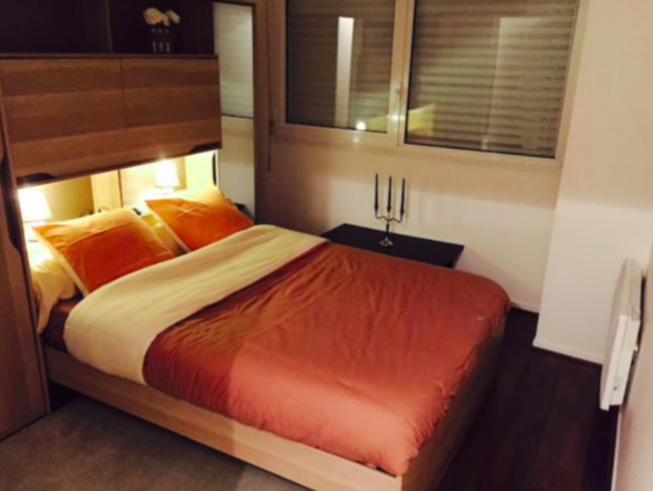 une chambre avec un grand lit avec des oreillers orange dans l'établissement Sea Oceane, à La Rochelle