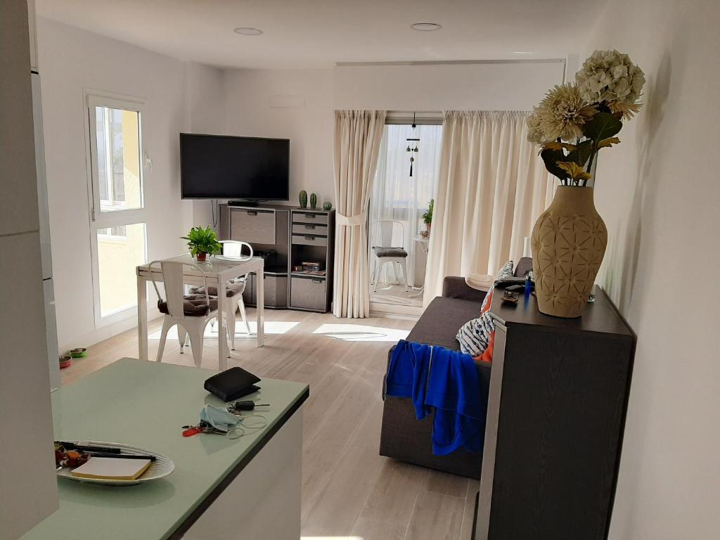 salon z wazą kwiatów na ladzie w obiekcie Arroyo mar & montaña cozy place w mieście Benalmádena