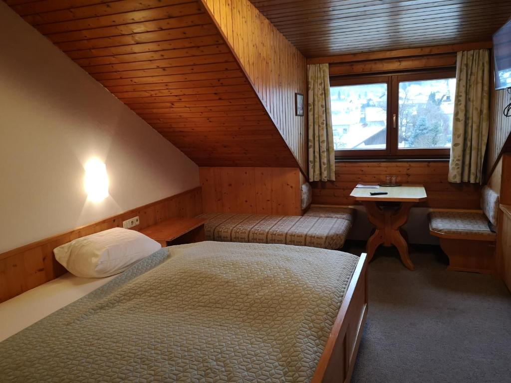 Piccola camera con letto, scrivania e finestra. di Hotel Wirt Z'Minsta ad Altmünster